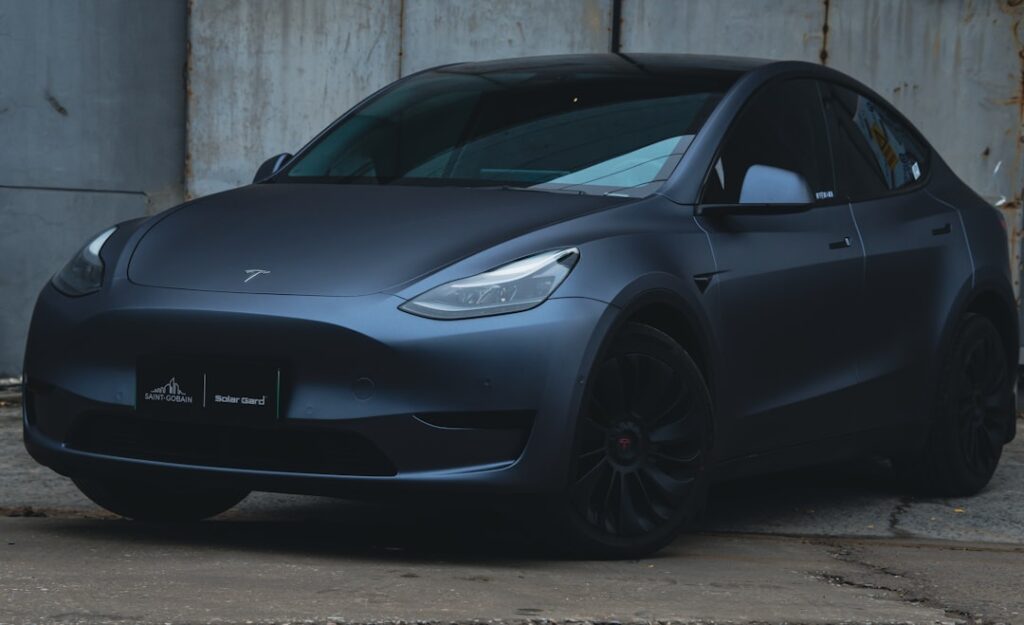 Tesla Model Y parkeret ved en lagerbygning