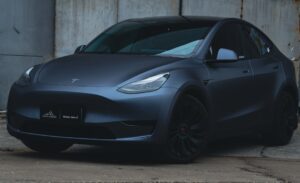 Tesla Model Y parkeret ved en lagerbygning