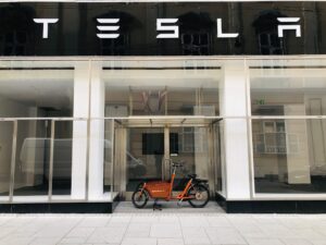 Butiksfront med Tesla skilt og orange lastcykel