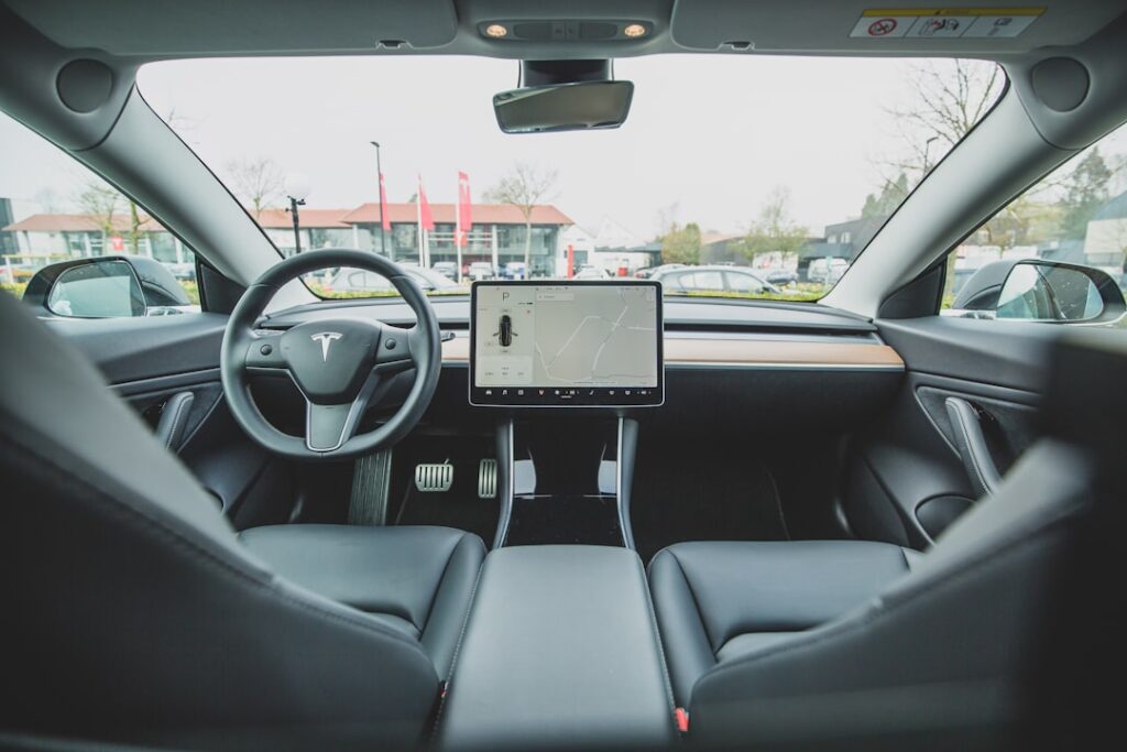 Tesla Model 3 interiør med touchskærm, parkeret udenfor