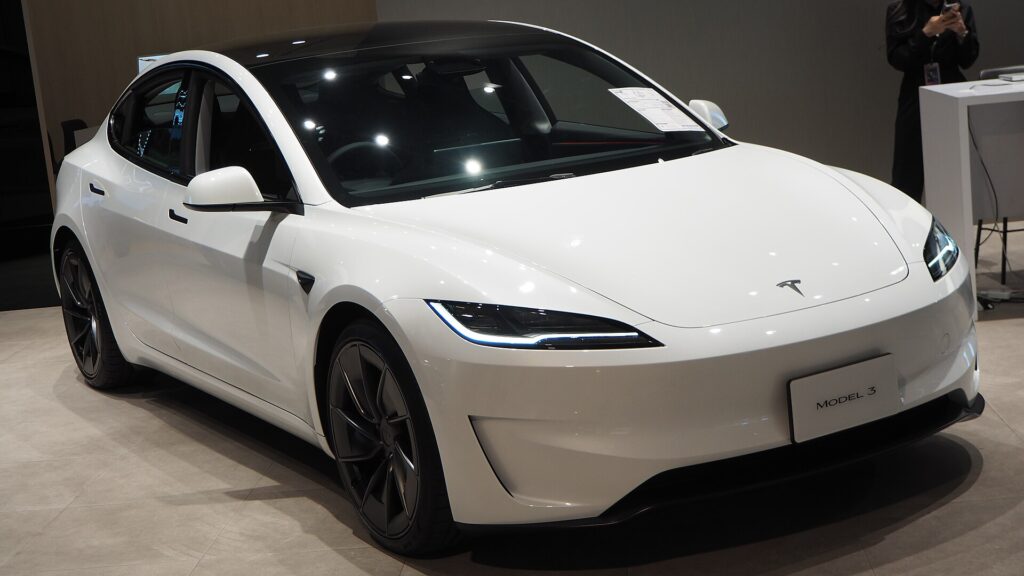 Hvid Tesla Model 3 Performance med mørke fælge i et showroom