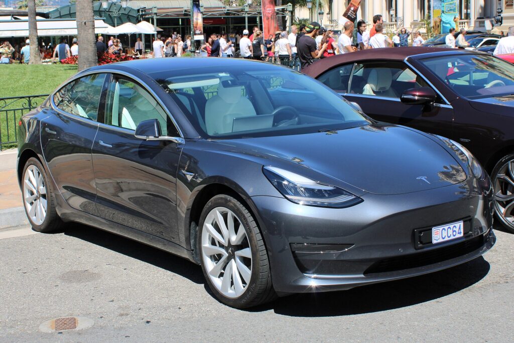 Mørkegrå Tesla Model 3 af den første generation med hvide fælge parkeret i Monaco