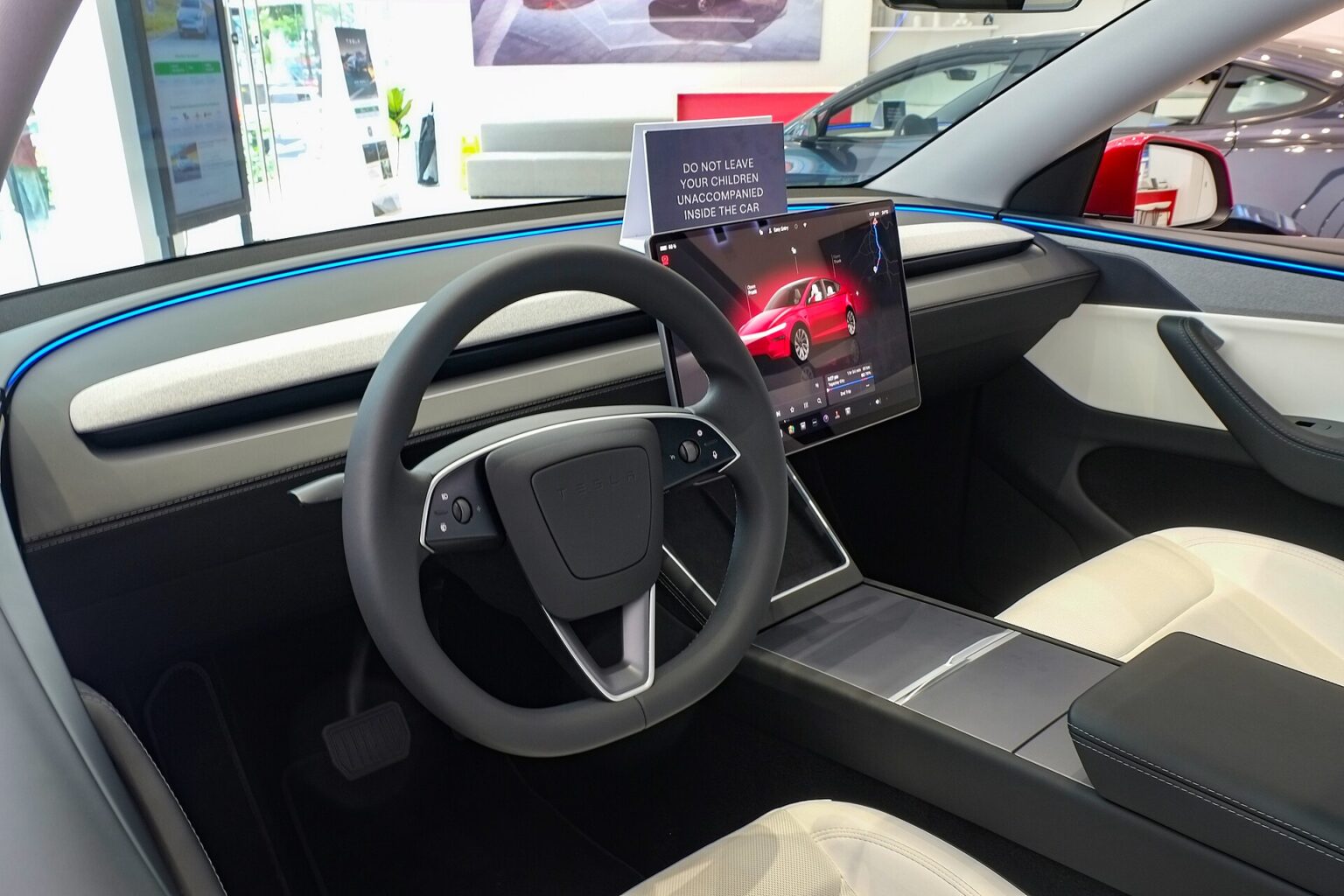 Kabine i en Tesla Model Y af den nye generation med rat og den store midterskærm