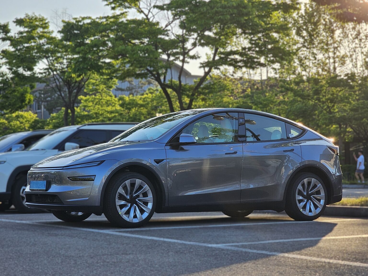 Grå Tesla Model Y af den nye generation parkeret på en parkeringsplads