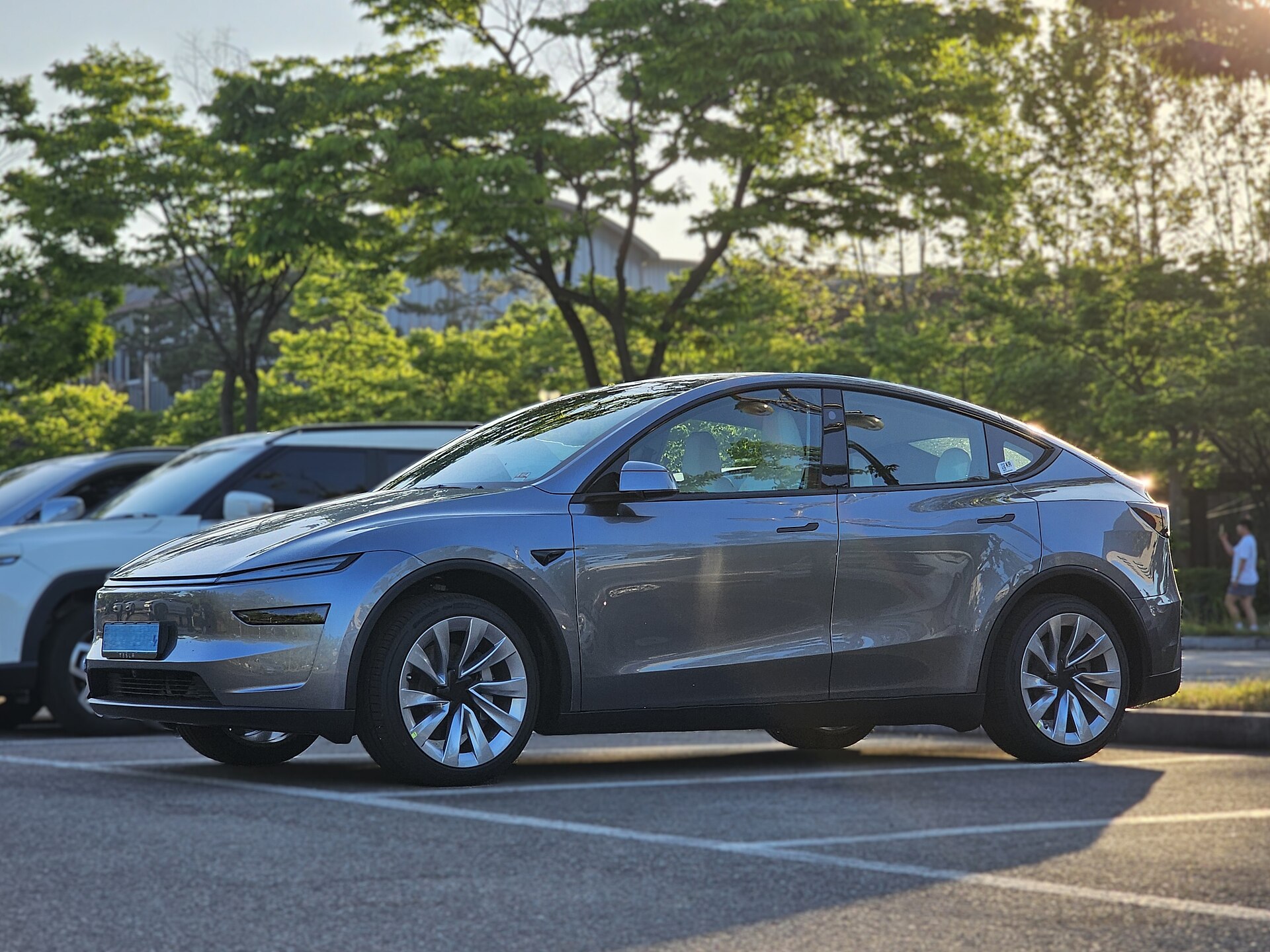 Grå Tesla Model Y af den nye generation parkeret på en parkeringsplads