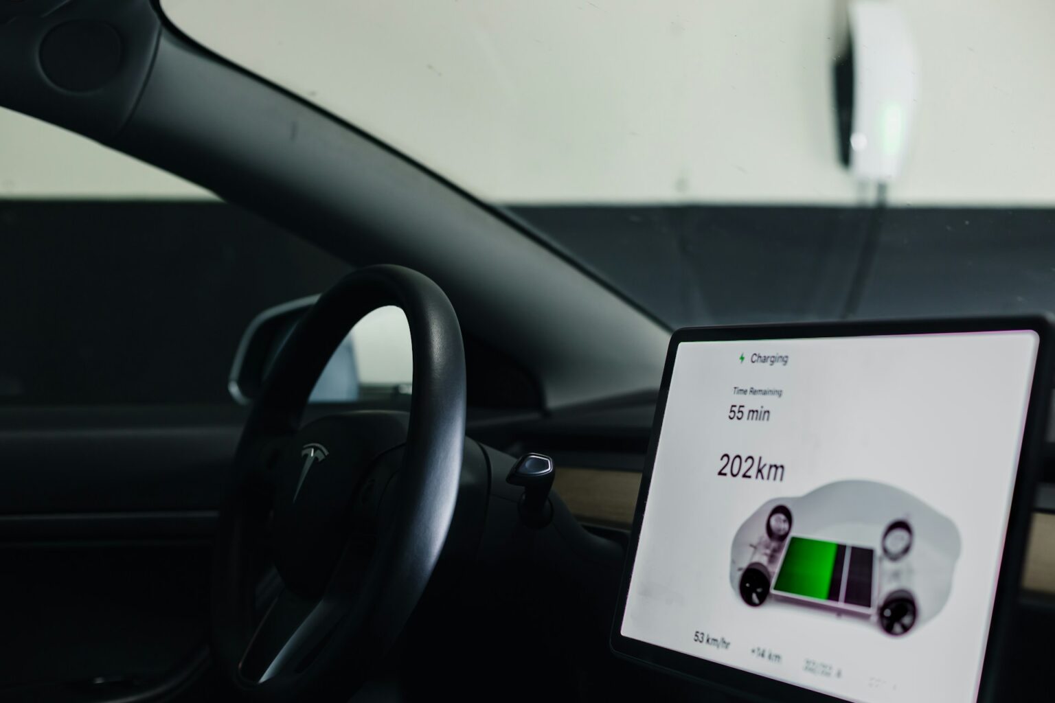 Opladningsskærmen i en Tesla viser resterende ladetid og rækkevidde, mens bilen lader fra en Wall Connector