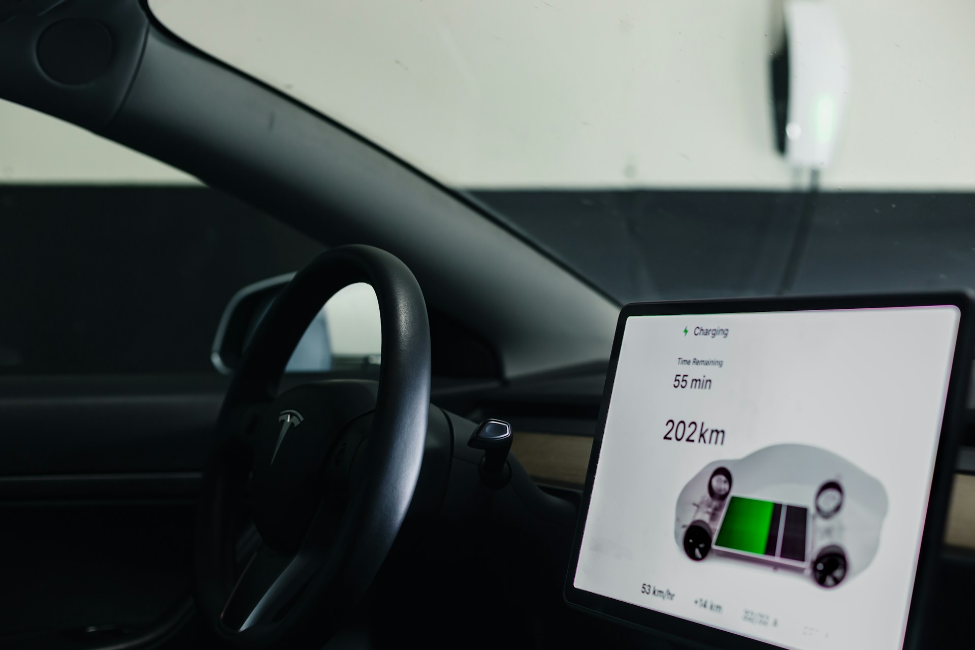 Opladningsskærmen i en Tesla viser resterende ladetid og rækkevidde, mens bilen lader fra en Wall Connector