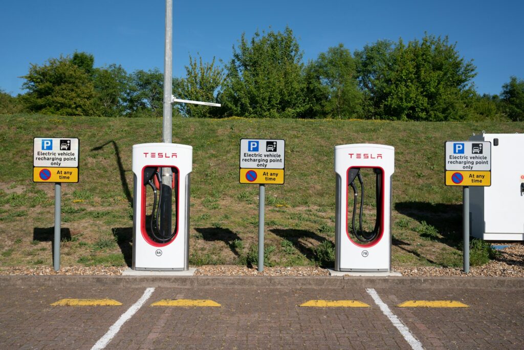 Række af Tesla Supercharger-standere med parkeringsskilte for opladning